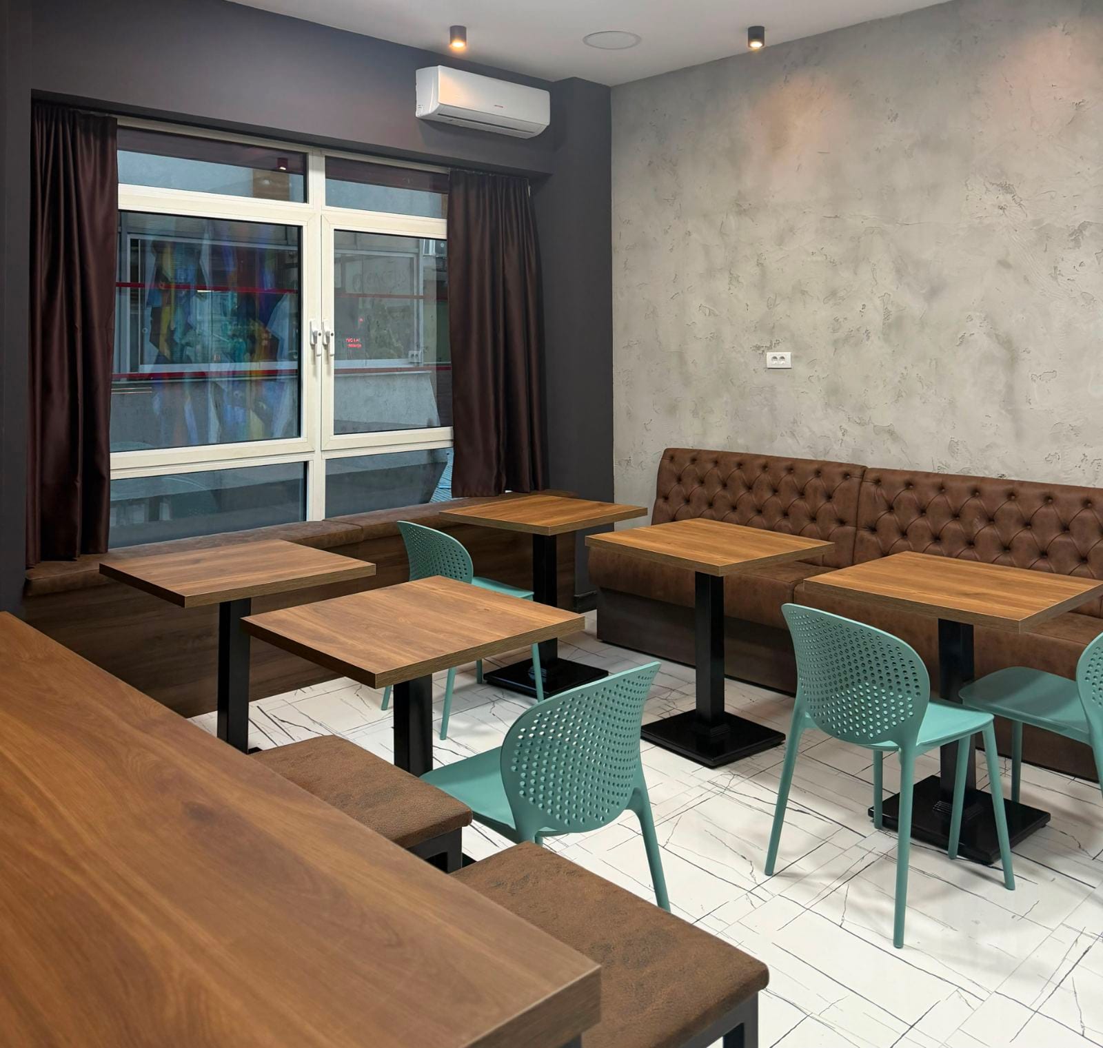 Sedeći deo prostora Paradox Kafe sa drvenim stolovima i klupama